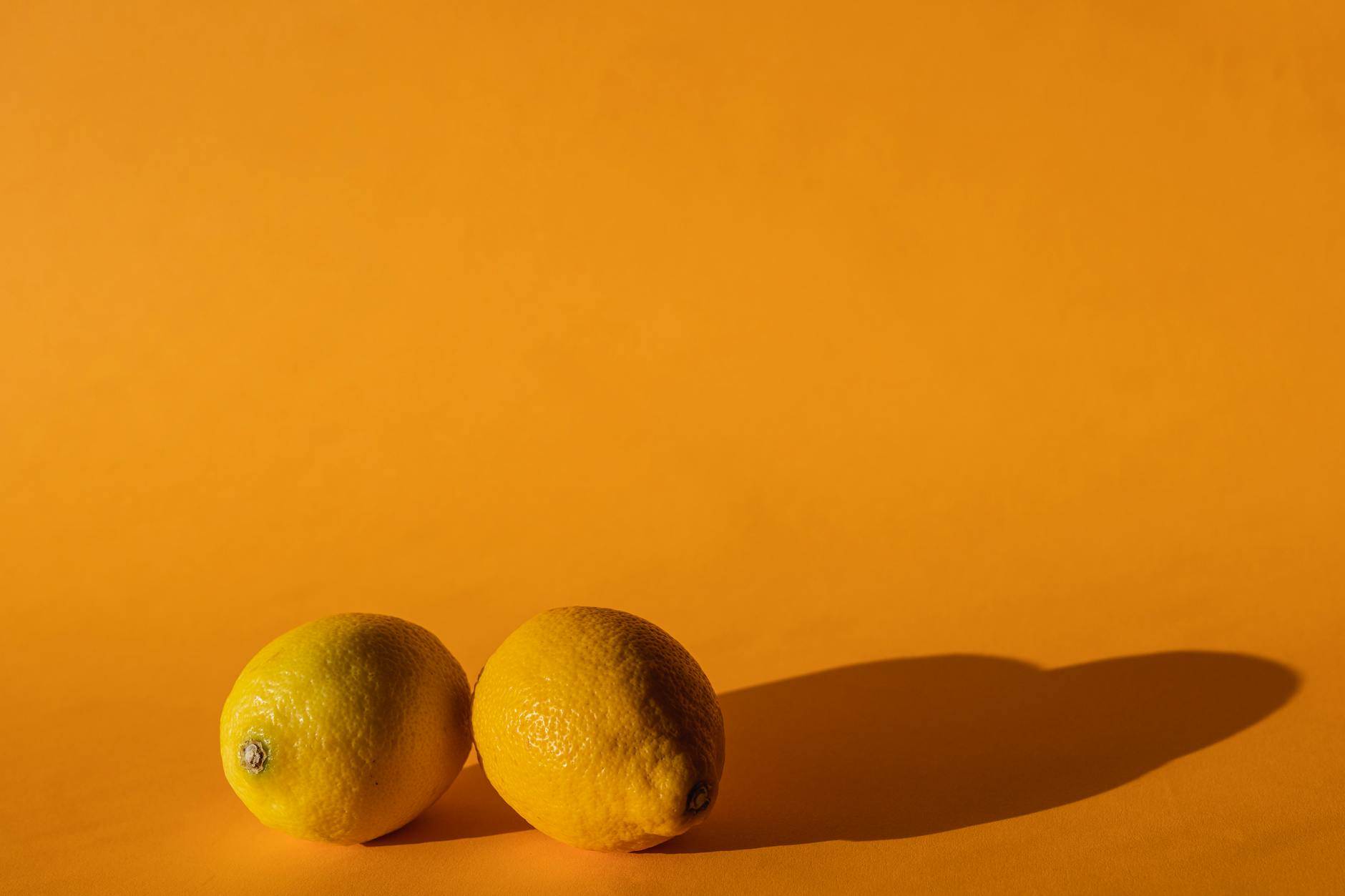 Fresh lemons on a bright yellow background, symbolizing renewal and gentle awakening
